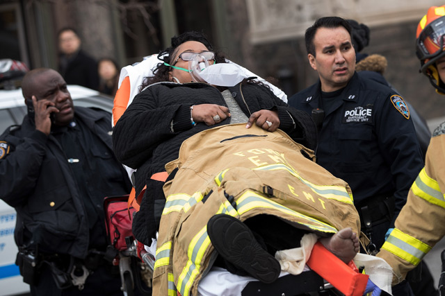 Members of the New York City Police Department and New York City Fire Department carry an injured person away from Atlantic Terminal. (AFP)